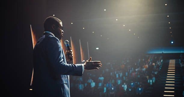 A speaker on stage before an audience